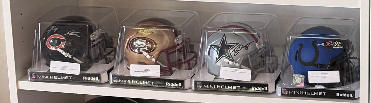 A row of cased mini helmets on the collection shelf