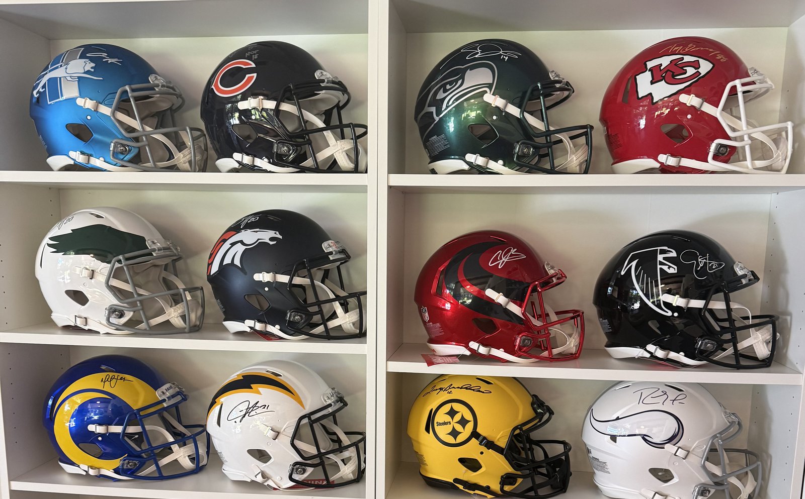 The signed helmet collection on its shelves